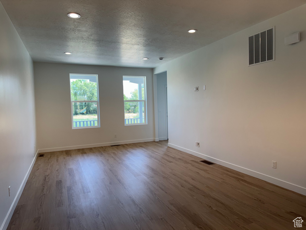 Empty room featuring wood finished floors, recessed lighting, and a textured ceiling