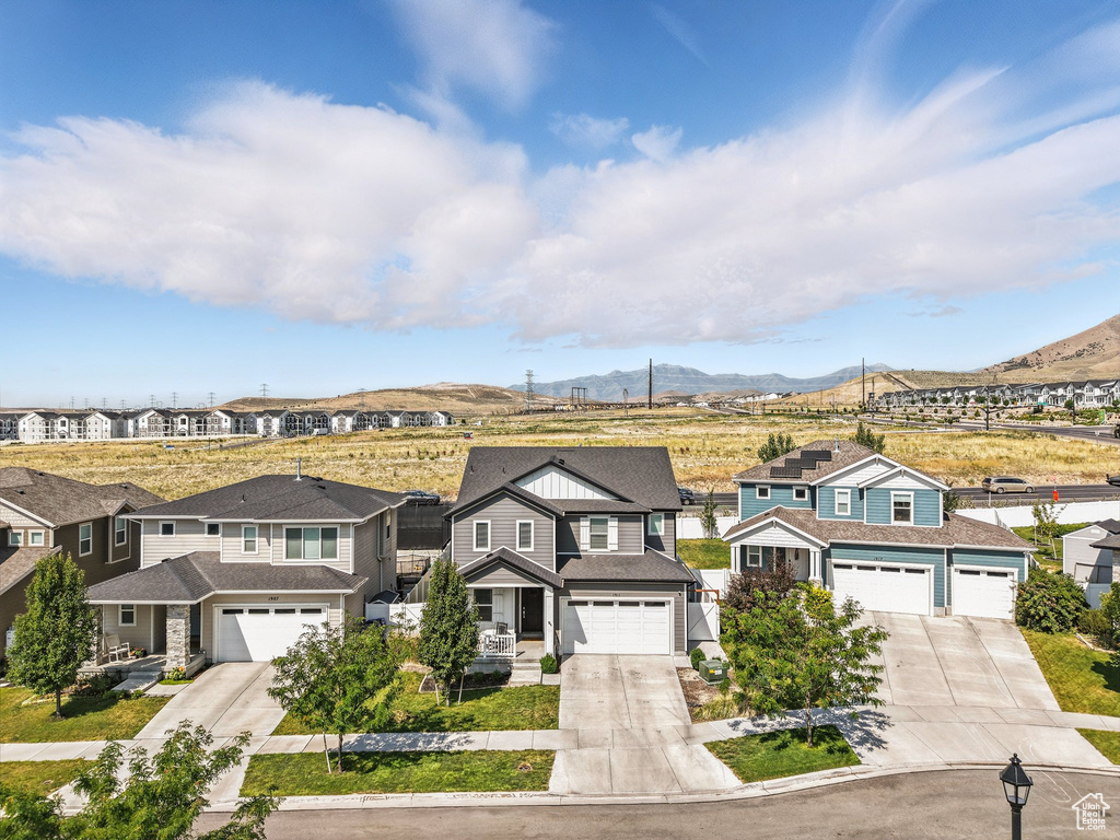 View of front facade with driveway, a mountain view, and a residential view