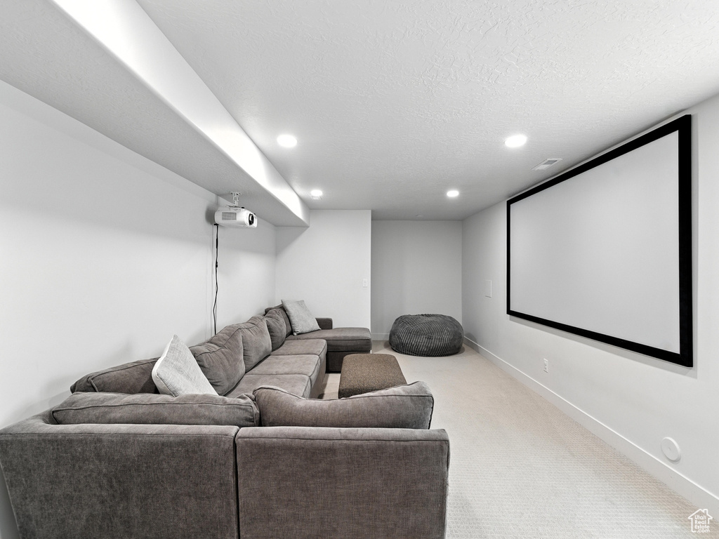 Carpeted home theater room featuring recessed lighting and a textured ceiling