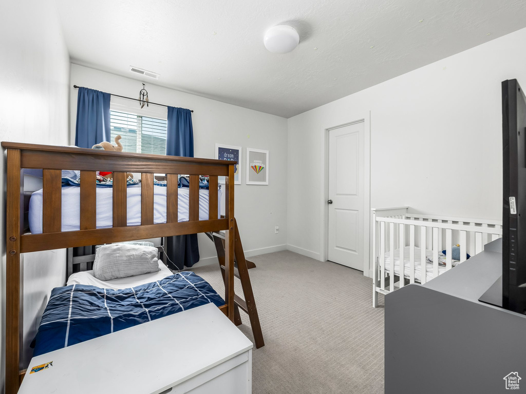 Bedroom featuring carpet and baseboards