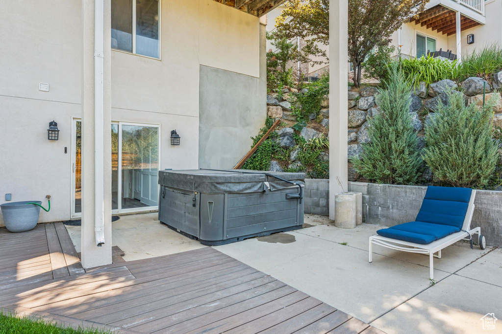 Deck featuring a hot tub and a patio area