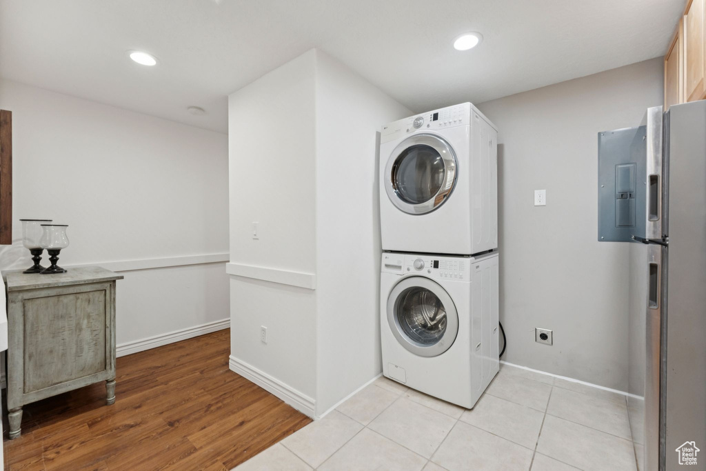 Laundry room with estacked washer and dryer, electric panel, recessed lighting, and light wood-style floors