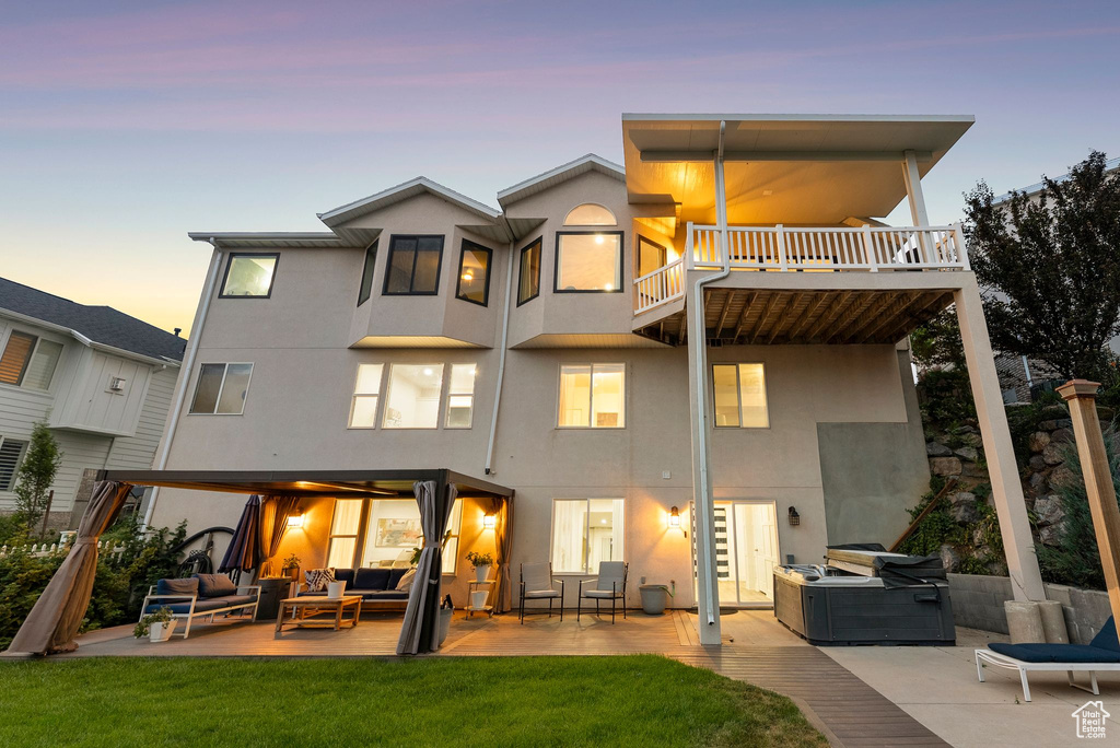 Rear view of house with an outdoor hangout area, stucco siding, a patio, and a lawn