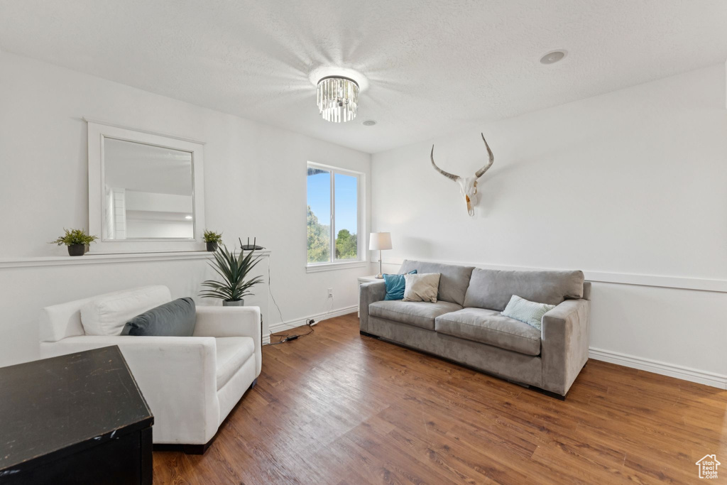 Living area featuring wood finished floors and a chandelier