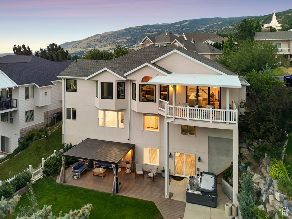 Back of property with a balcony, outdoor lounge area, stucco siding, and a mountain view