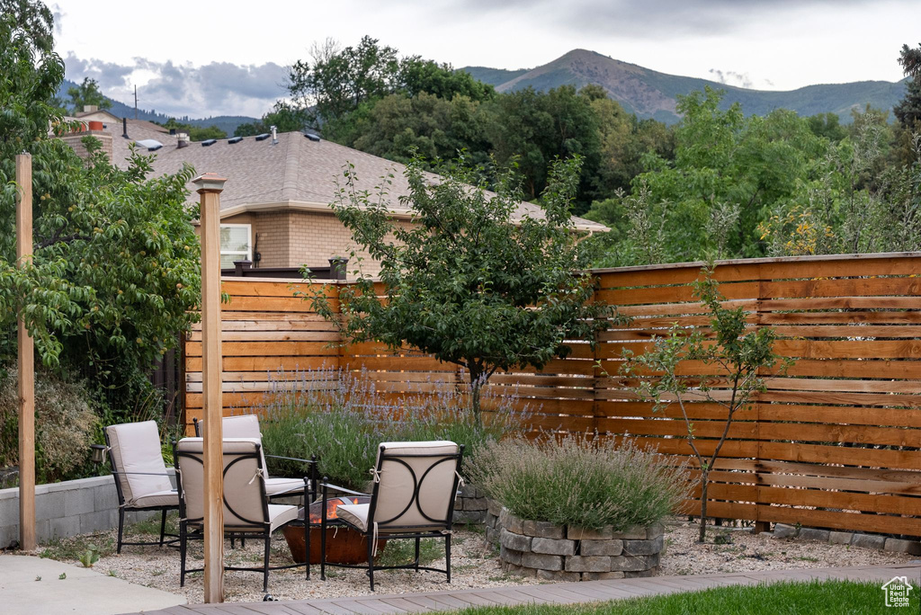 Fenced backyard featuring a patio area, a mountain view, and outdoor dining area