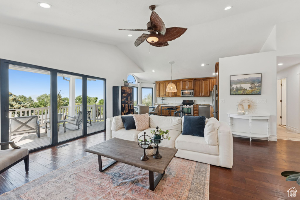 Living room with high vaulted ceiling, recessed lighting, ceiling fan, and wood-type flooring