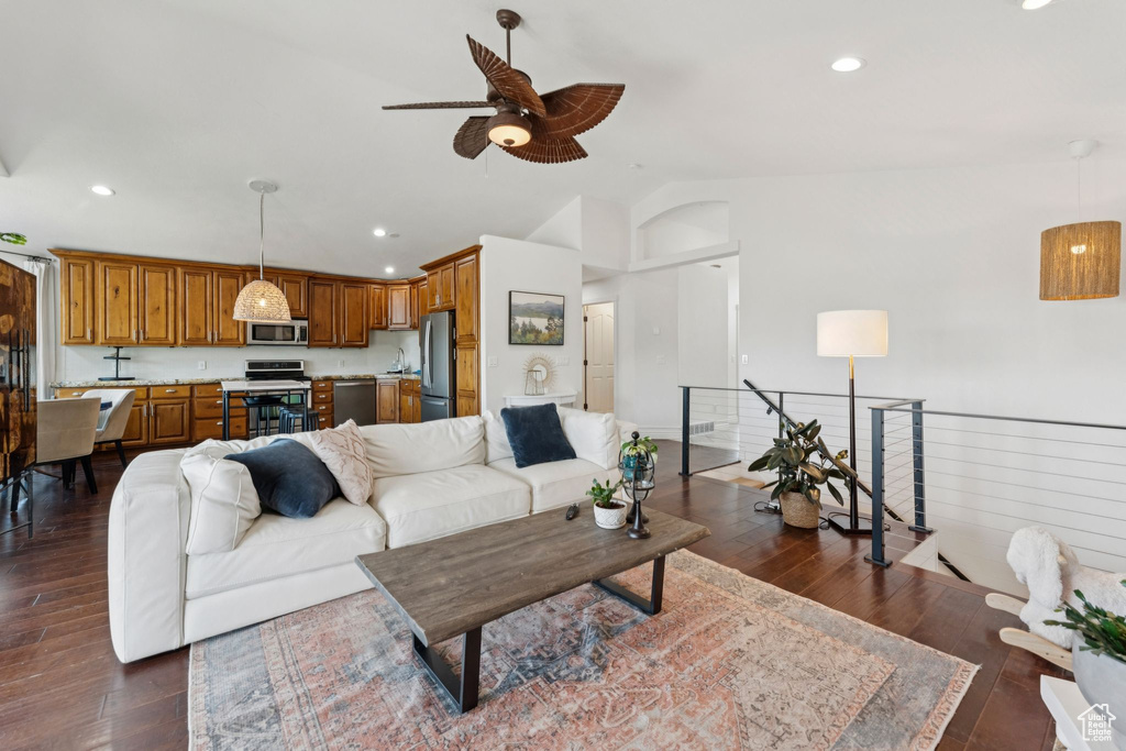 Living room featuring a ceiling fan, lofted ceiling, dark wood-style flooring, and recessed lighting