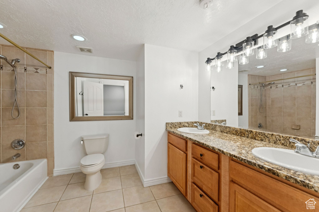 Bathroom with double vanity, a textured ceiling, tile patterned floors, bathtub / shower combination, and recessed lighting