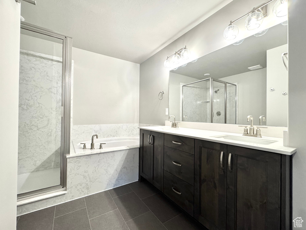 Bathroom with a garden tub, a stall shower, double vanity, and tile patterned flooring