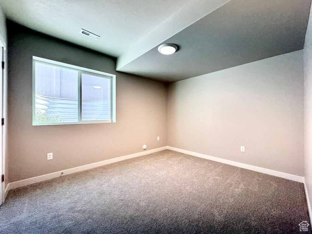 Carpeted spare room featuring baseboards and a textured ceiling