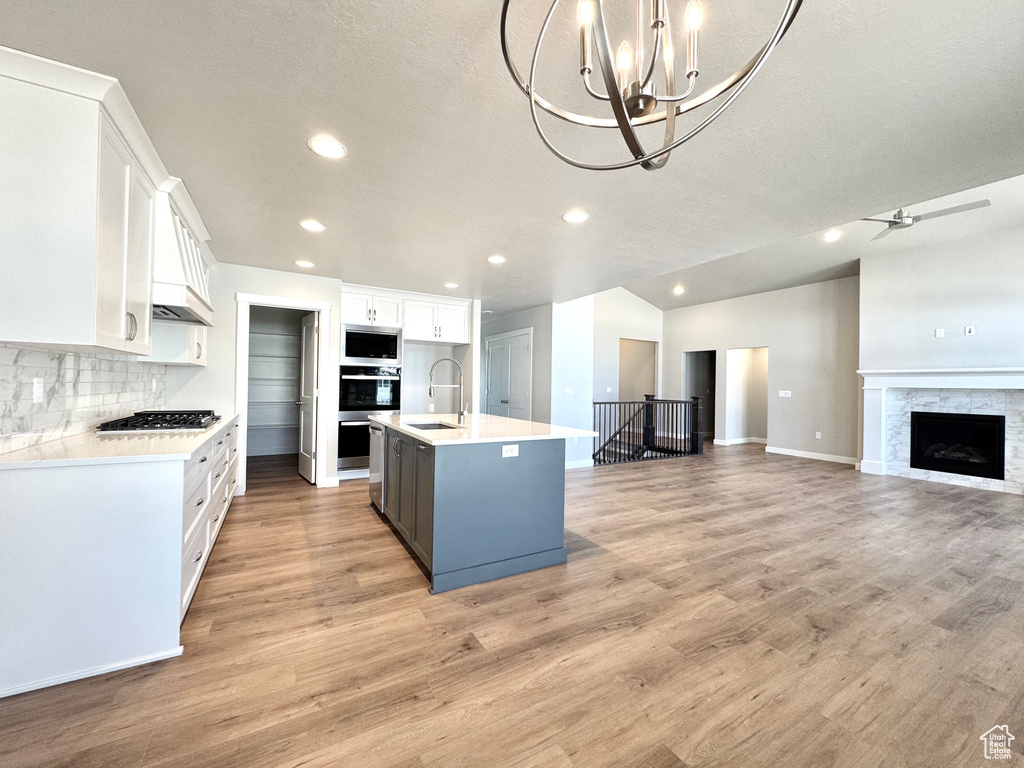 Kitchen with open floor plan, white cabinetry, appliances with stainless steel finishes, recessed lighting, and light countertops