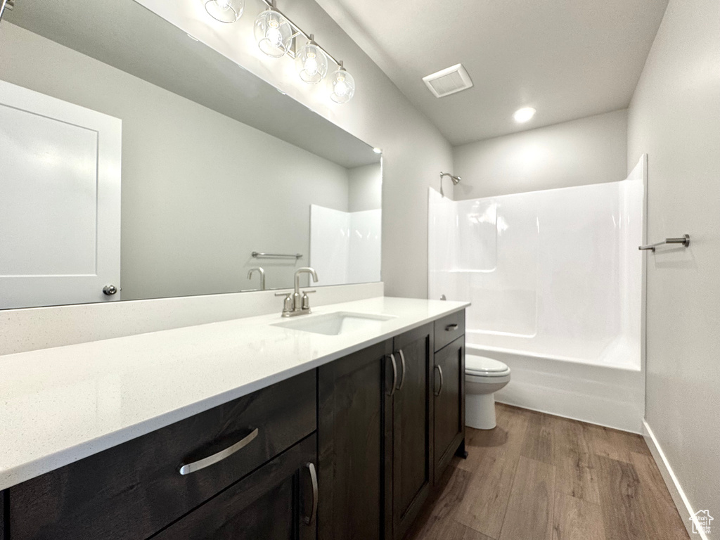 Bathroom with wood finished floors, vanity, and  shower combination
