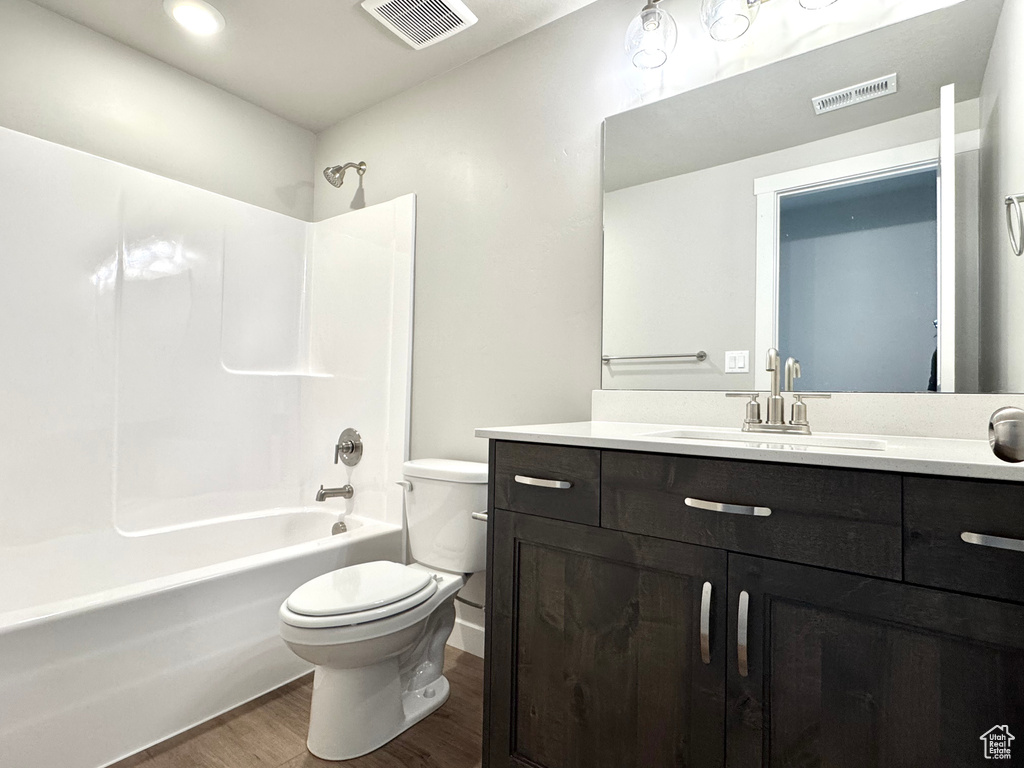 Full bath featuring wood finished floors, vanity, and shower / tub combination