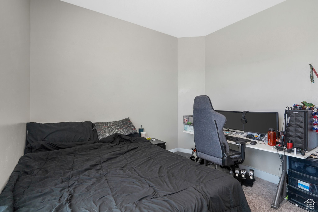 Bedroom with carpet flooring and a desk