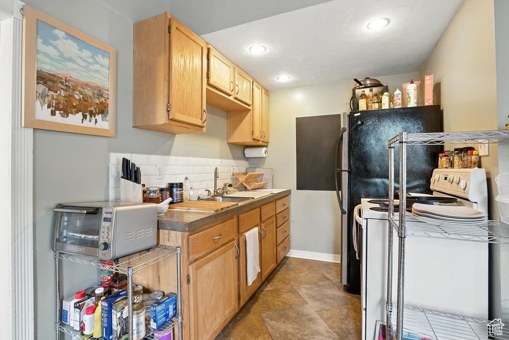 Kitchen featuring electric stove, tasteful backsplash, recessed lighting, and light brown cabinets