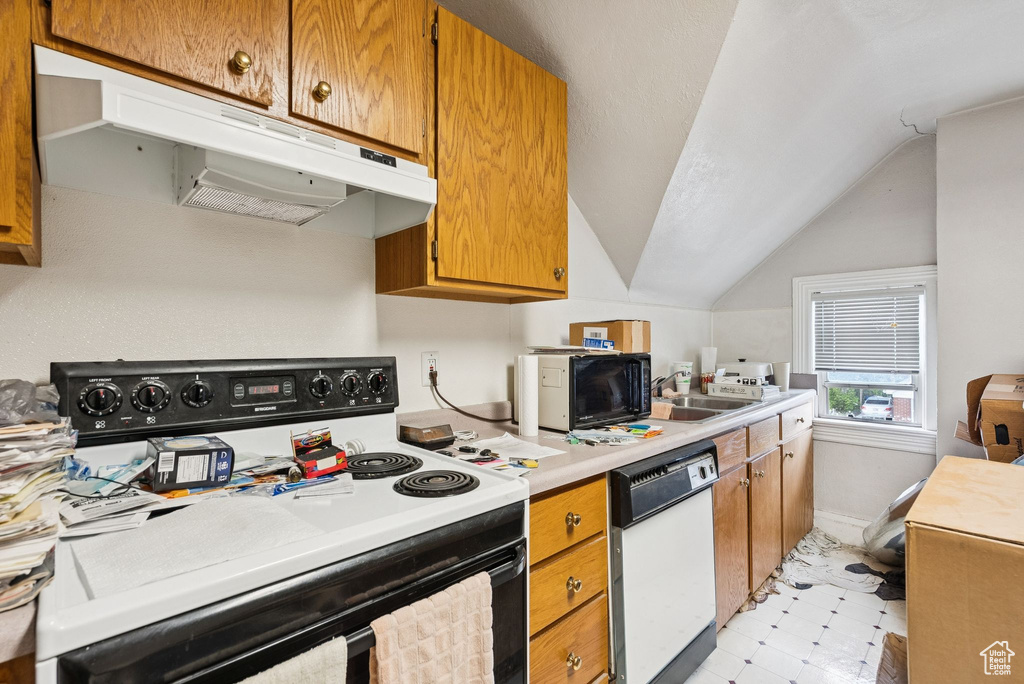 Kitchen with electric stove, white dishwasher, under cabinet range hood, lofted ceiling, and light countertops