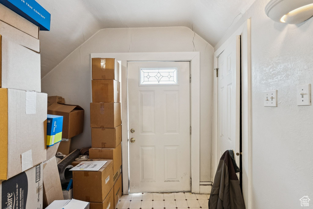 Foyer featuring vaulted ceiling and light flooring