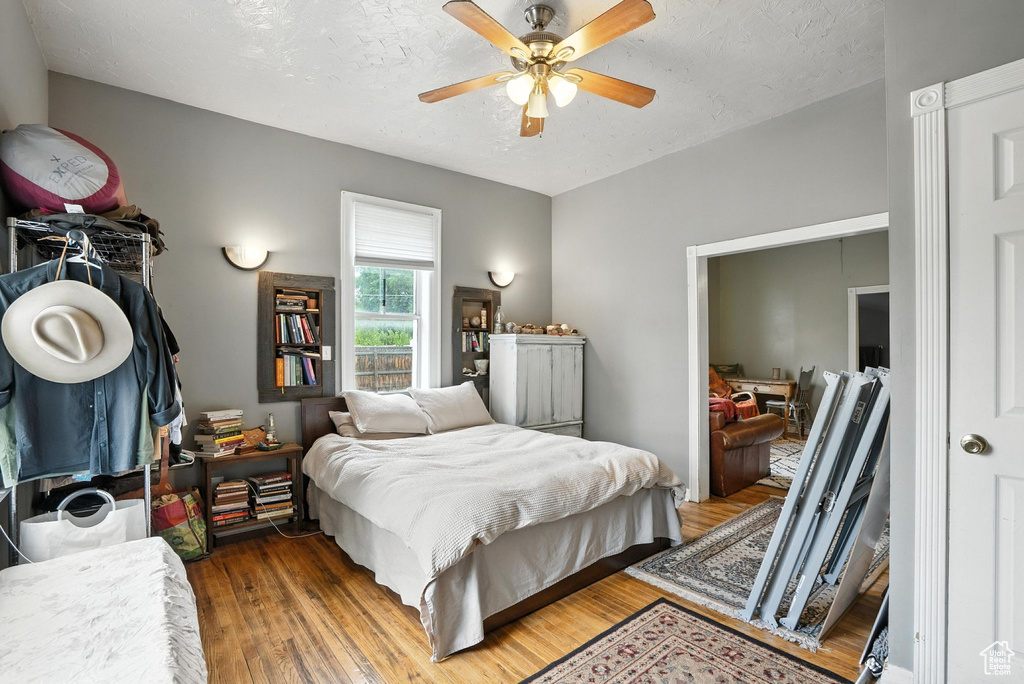 Bedroom featuring wood finished floors, a textured ceiling, and ceiling fan