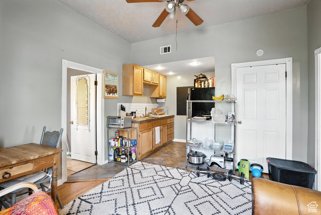 Kitchen with ceiling fan and light brown cabinetry