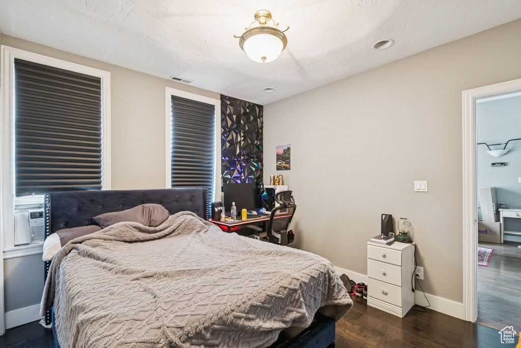 Bedroom with wood finished floors and baseboards