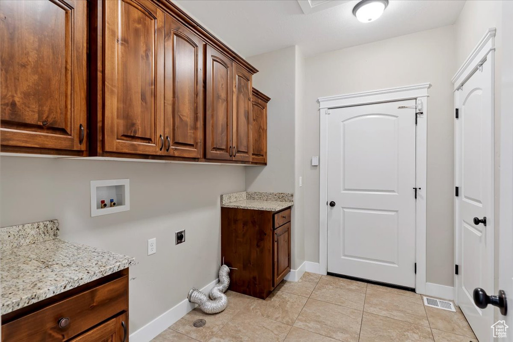 Laundry room featuring cabinet space, washer hookup, hookup for an electric dryer, and light tile patterned floors