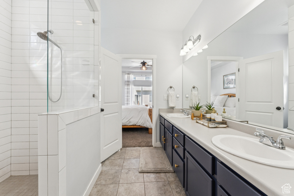 Bathroom featuring ensuite bath, double vanity, a ceiling fan, walk in shower, and tile patterned flooring