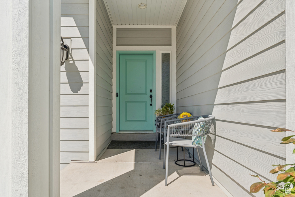 Doorway to property featuring covered porch