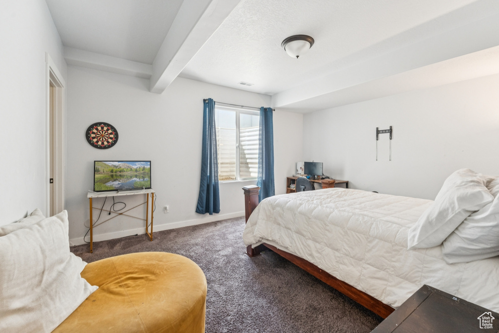 Carpeted bedroom featuring beamed ceiling and baseboards