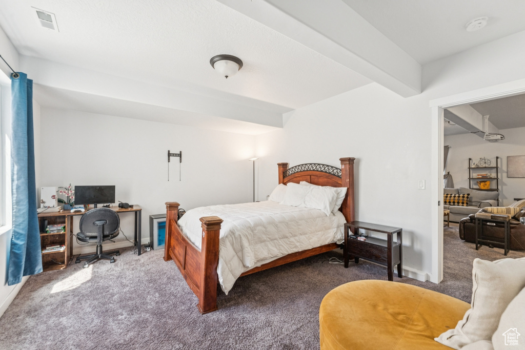 Carpeted bedroom featuring an office area and baseboards