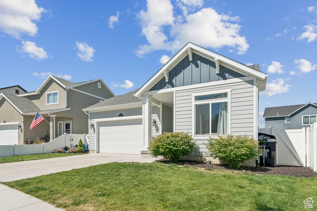 View of front of home with driveway, an attached garage, and board and batten siding