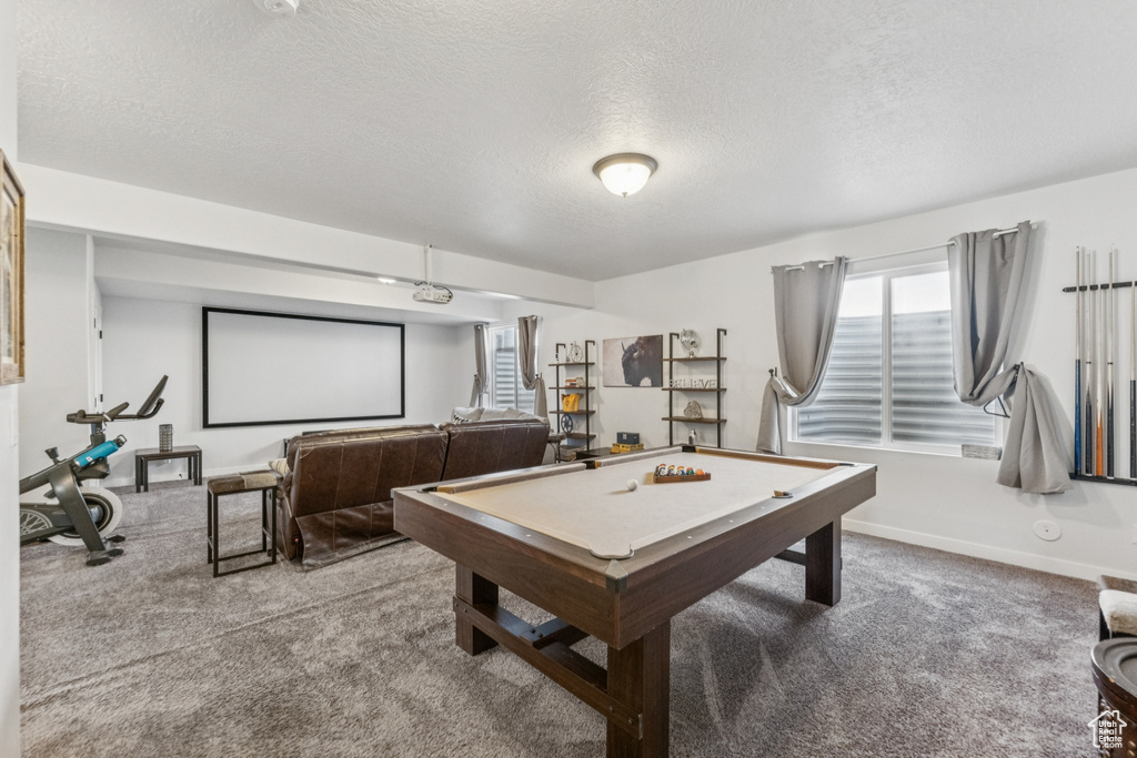 Game room with carpet, a textured ceiling, and billiards