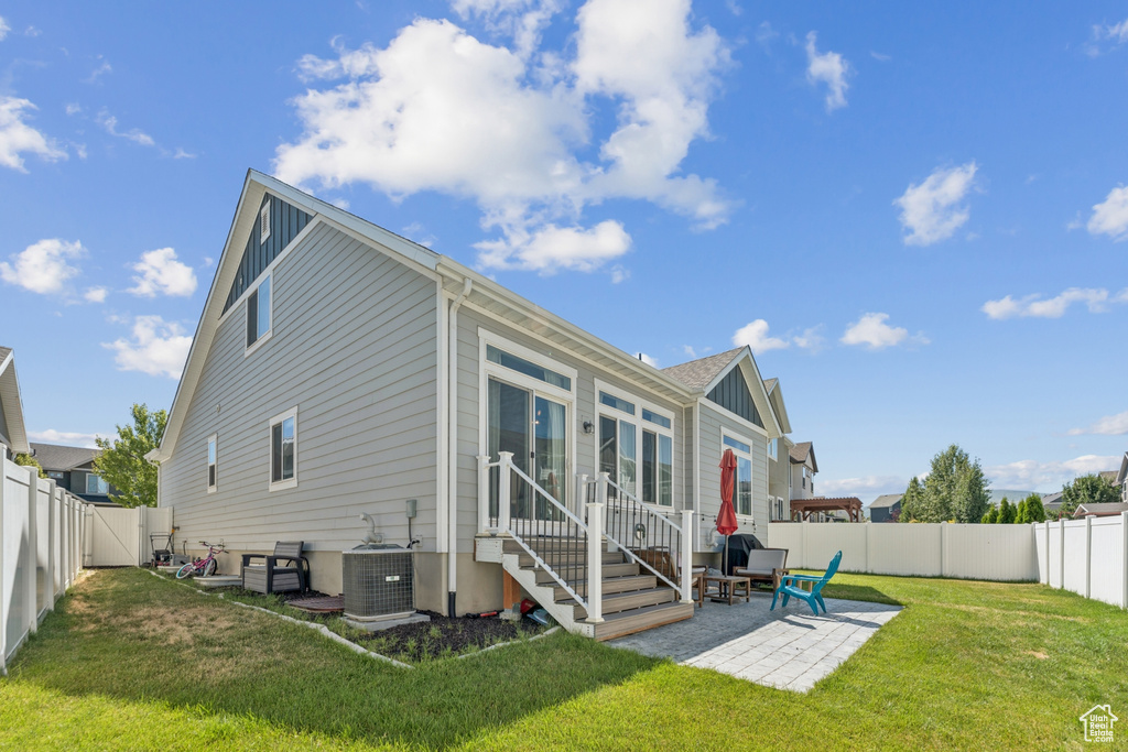 Back of house with entry steps, a fenced backyard, a patio area, and board and batten siding