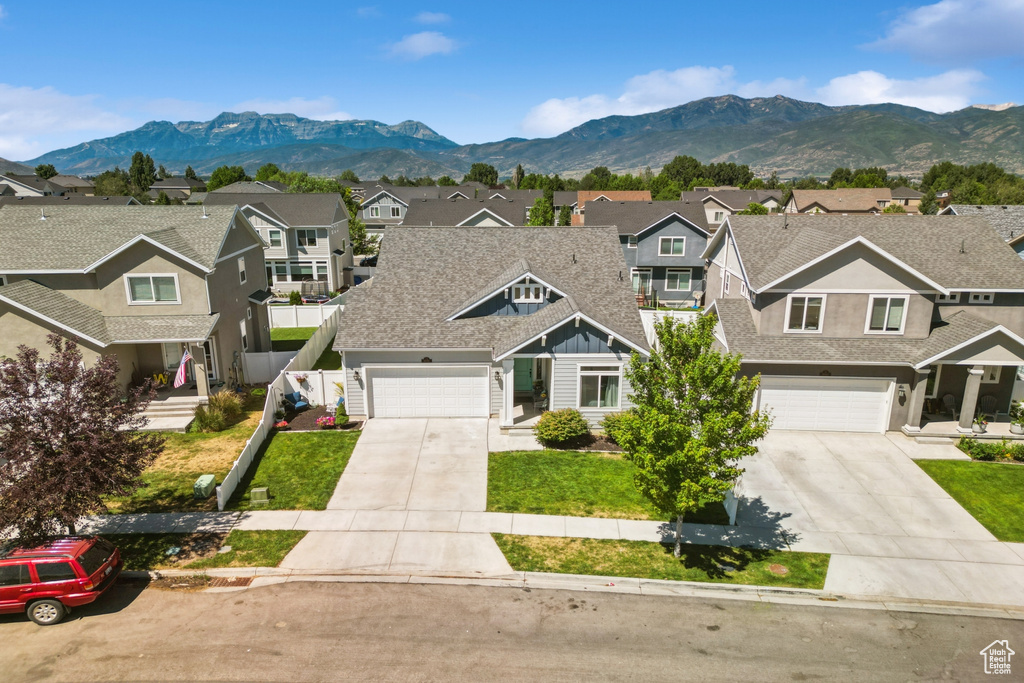 View of property with driveway, a residential view, and a mountain view
