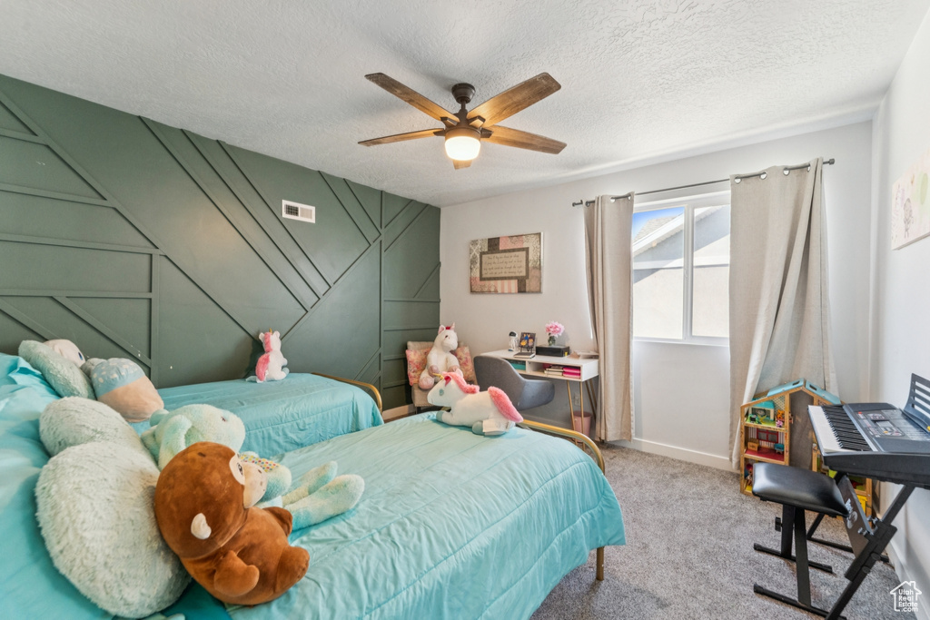 Bedroom with carpet, a ceiling fan, and a textured ceiling