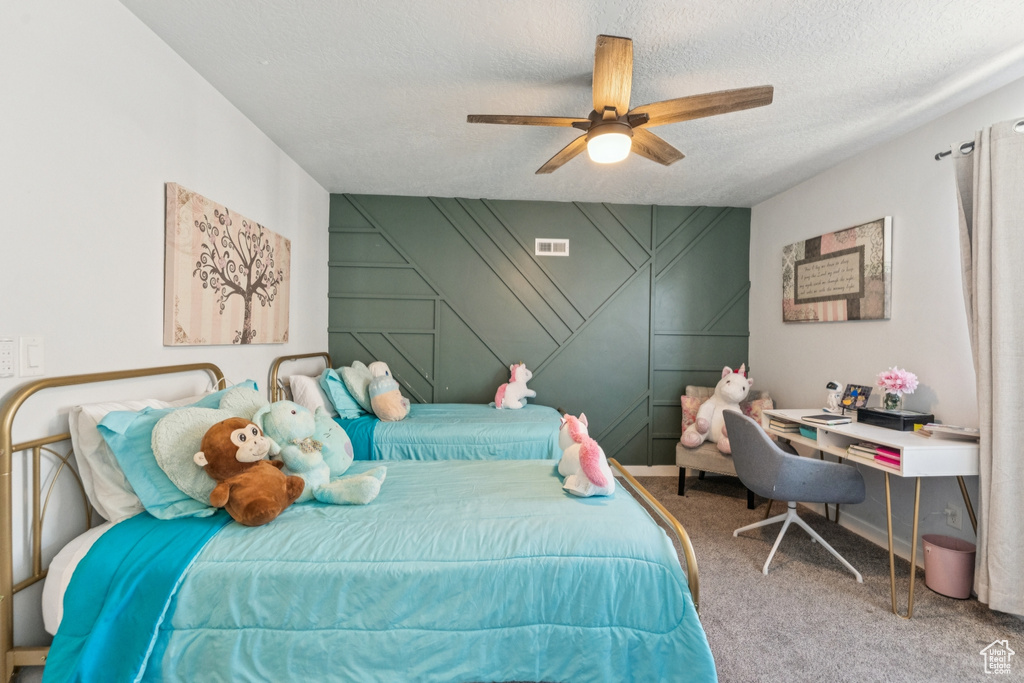 Carpeted bedroom featuring a textured ceiling and ceiling fan