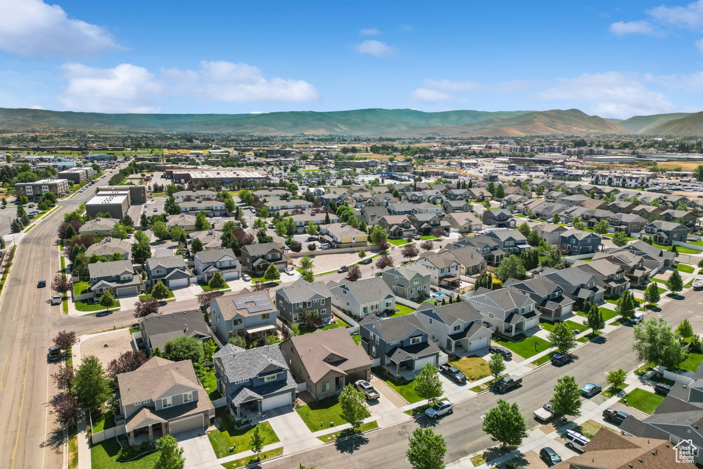 Aerial view of property and surrounding area featuring mountains and nearby suburban area