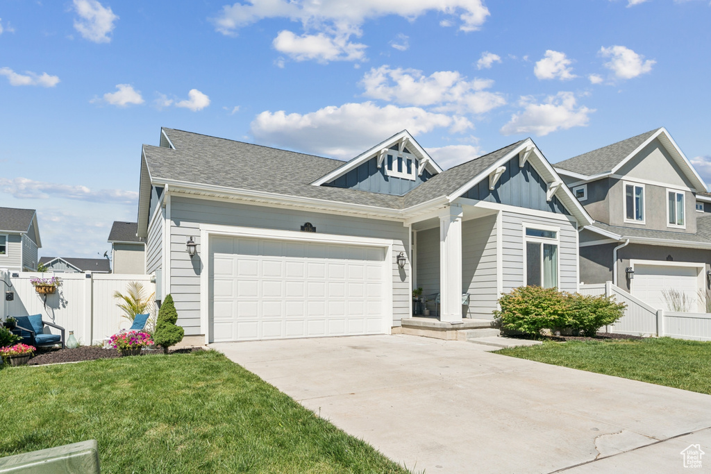 View of front of home with driveway, board and batten siding, and an attached garage