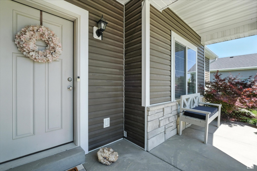Doorway to property featuring covered porch