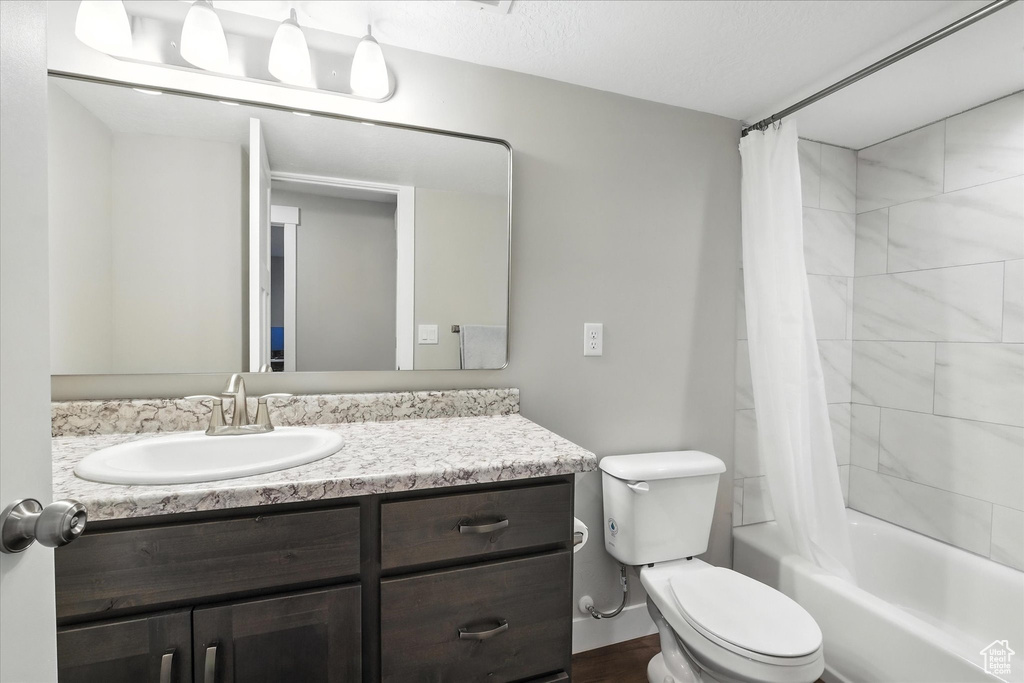 Full bathroom with vanity, shower / bath combination with curtain, and wood finished floors