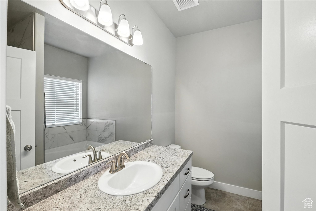 Bathroom with vanity, a bath, and tile patterned flooring
