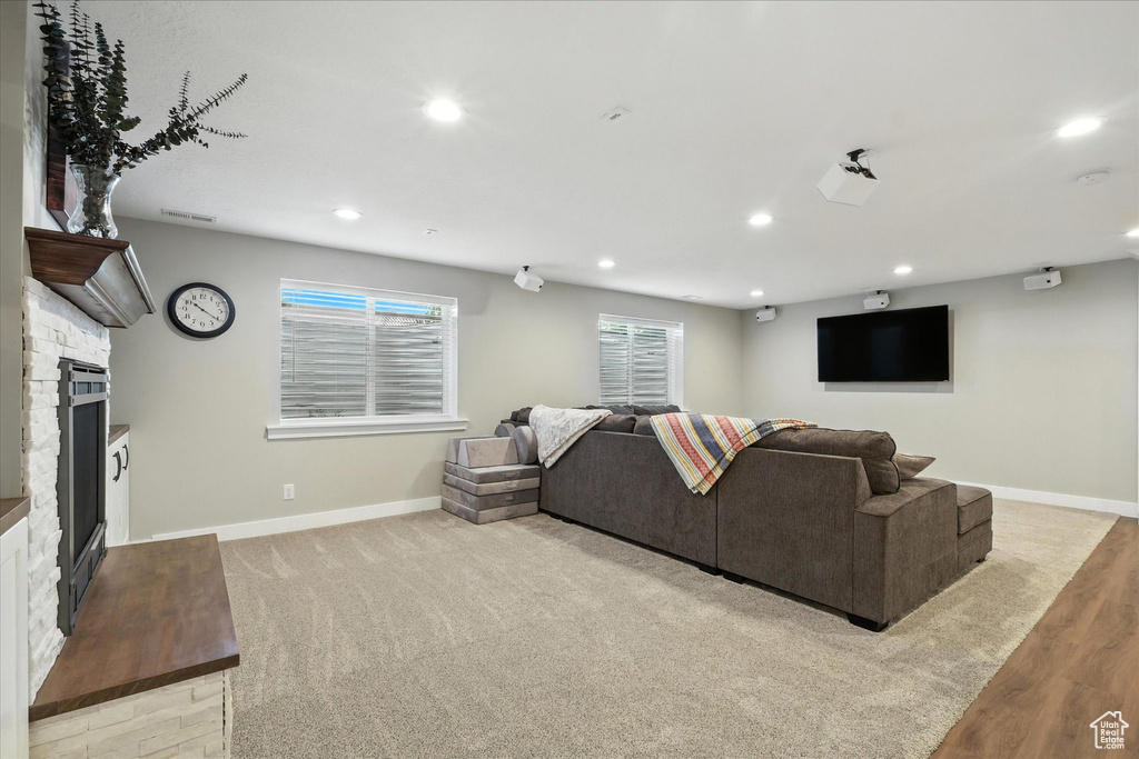 Living room with a fireplace, recessed lighting, and light wood-style flooring