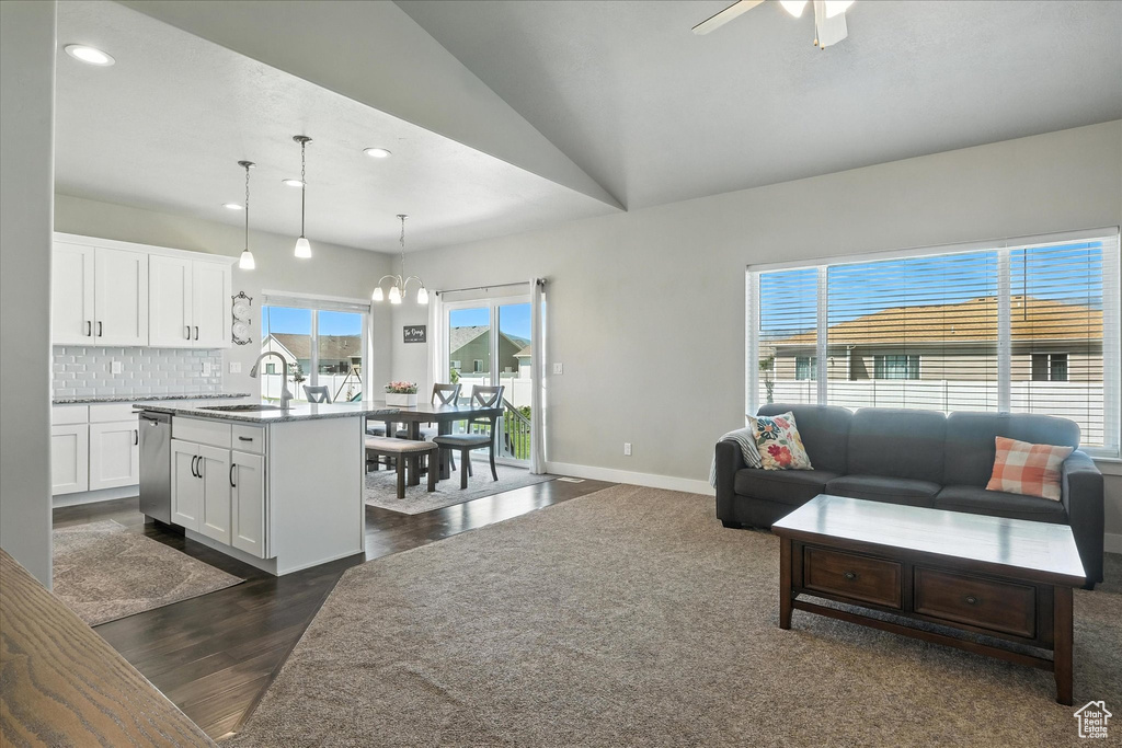Living room featuring recessed lighting, dark wood-style flooring, a chandelier, lofted ceiling, and ceiling fan