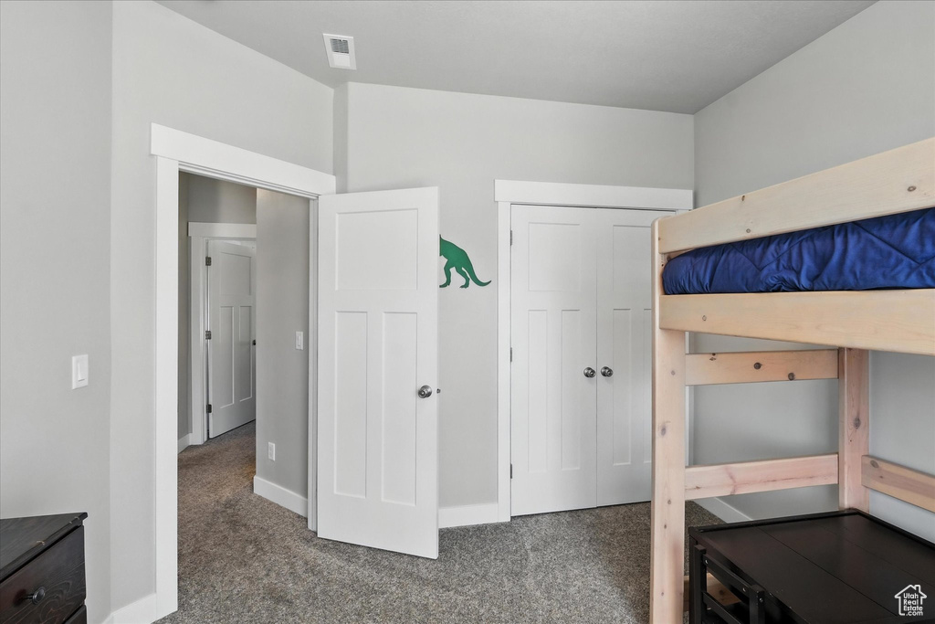Carpeted bedroom with a closet and baseboards