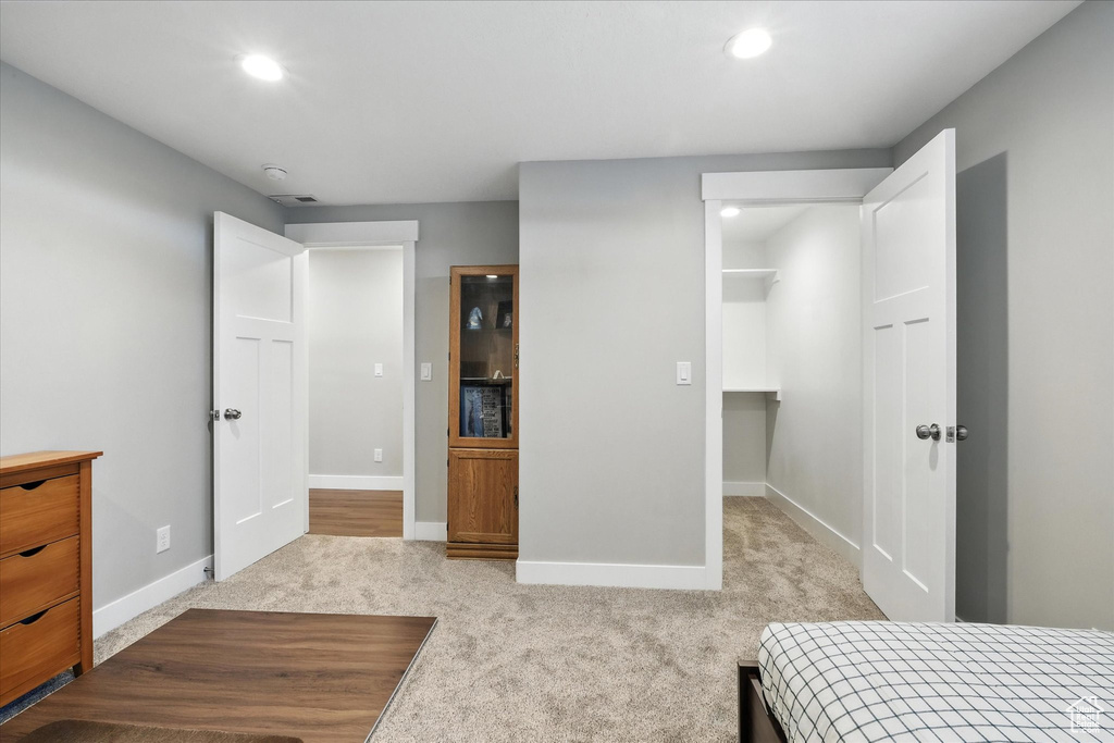 Bedroom with carpet, a spacious closet, and recessed lighting