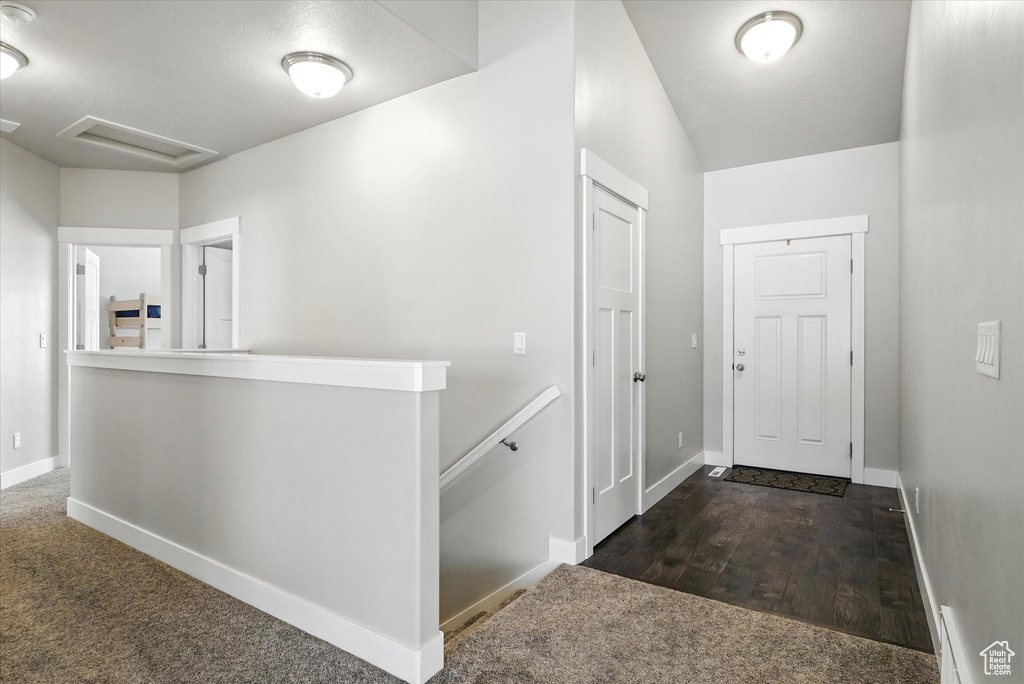 Hall with an upstairs landing, attic access, and carpet flooring