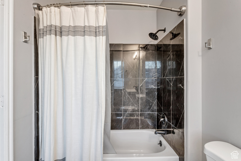 Bathroom featuring shower / tub combo and toilet