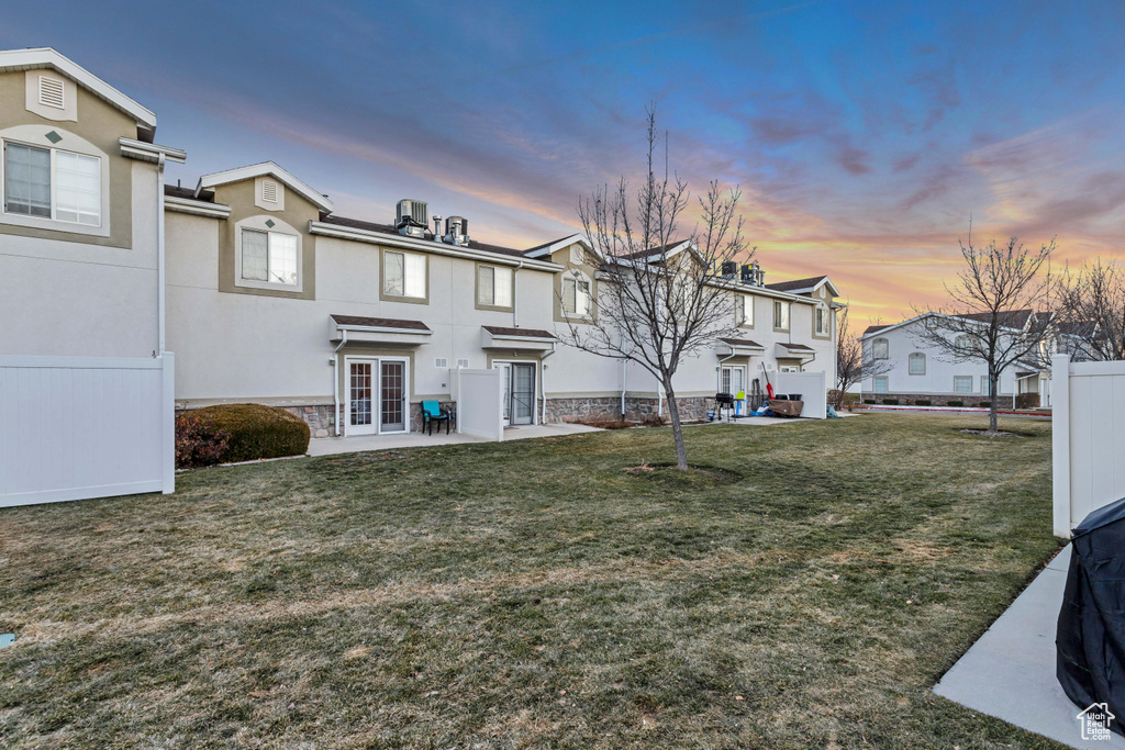 View of front of house featuring french doors, a residential view, a patio, stucco siding, and stone siding