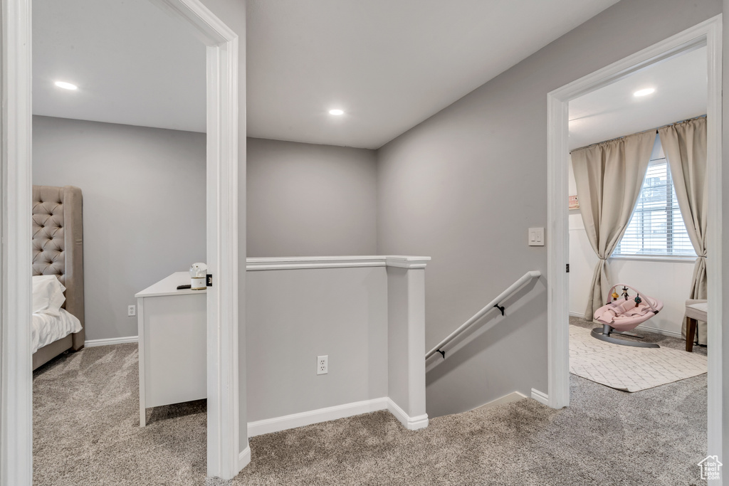 Hall with an upstairs landing, carpet floors, and recessed lighting