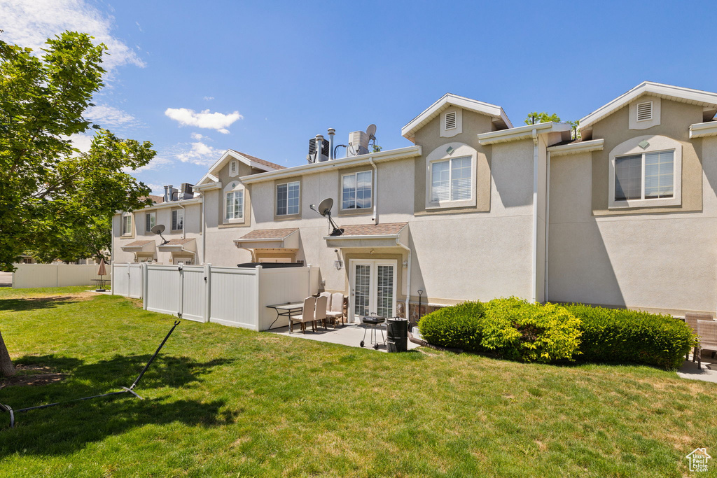 Back of property featuring french doors, stucco siding, and a patio
